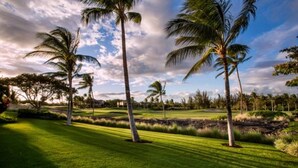 A well-maintained golf course with lush green grass, palm trees, and a clear sky. - Summer Special! Discover luxury at Leilani Kai, a 3BR condo in beautiful Waikoloa, HI. (Waikoloa Village)