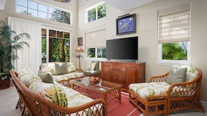 A spacious living room with wicker furniture, a flat-screen TV, and large windows with blinds. - Summer Special! Discover luxury at Leilani Kai, a 3BR condo in beautiful Waikoloa, HI. (Waikoloa Village)