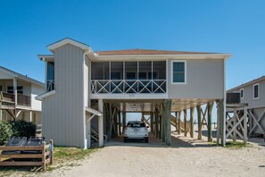 A two-story beach house with a covered entrance and a balcony. - McInnes 762 5 bedroom ocean front home on the South End of Pawleys! (Pawleys)