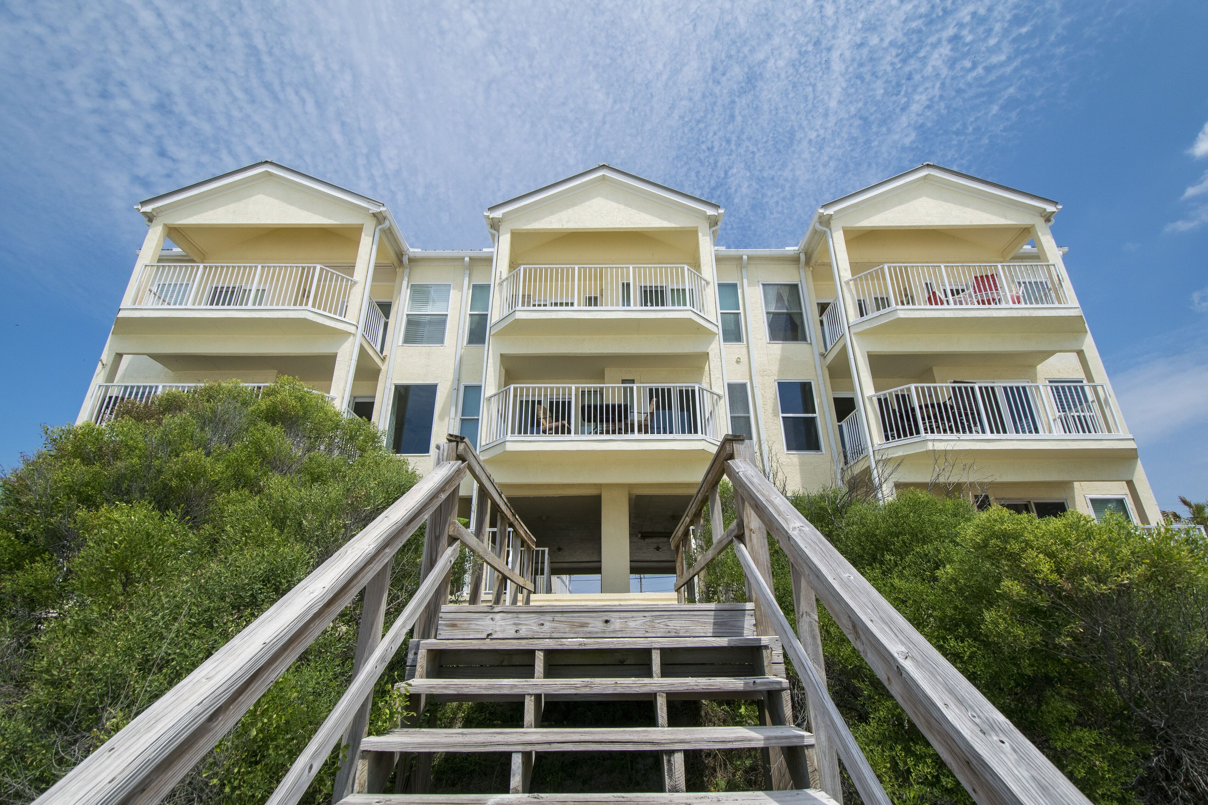 A multi-story hotel with a central staircase leading to the entrance.