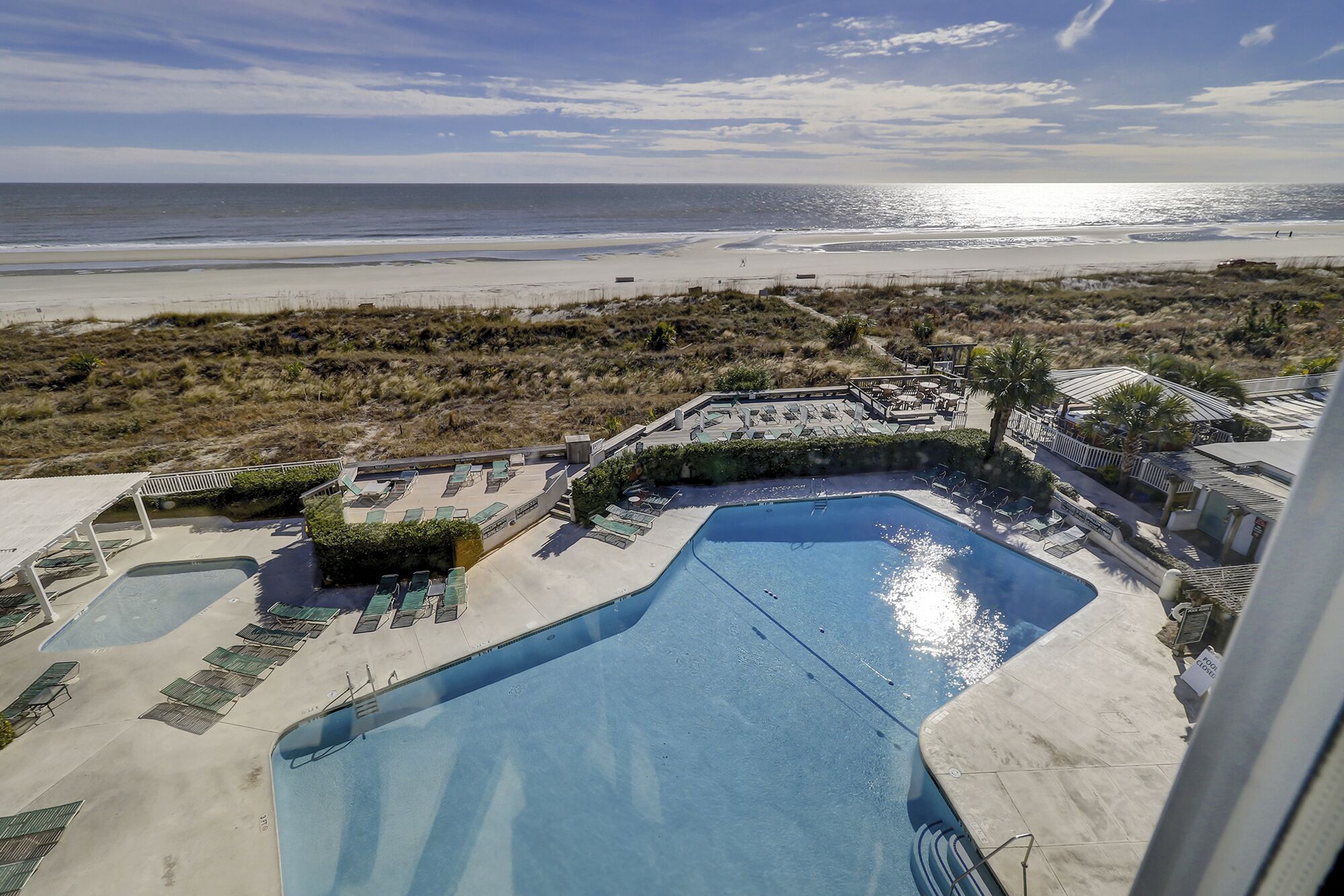 Um resort com uma piscina grande, espreguiçadeiras e vista para a praia.