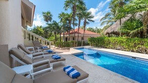 Un espace aménagé au bord de la piscine, avec des chaises longues et une piscine à l’eau d’un bleu limpide.
