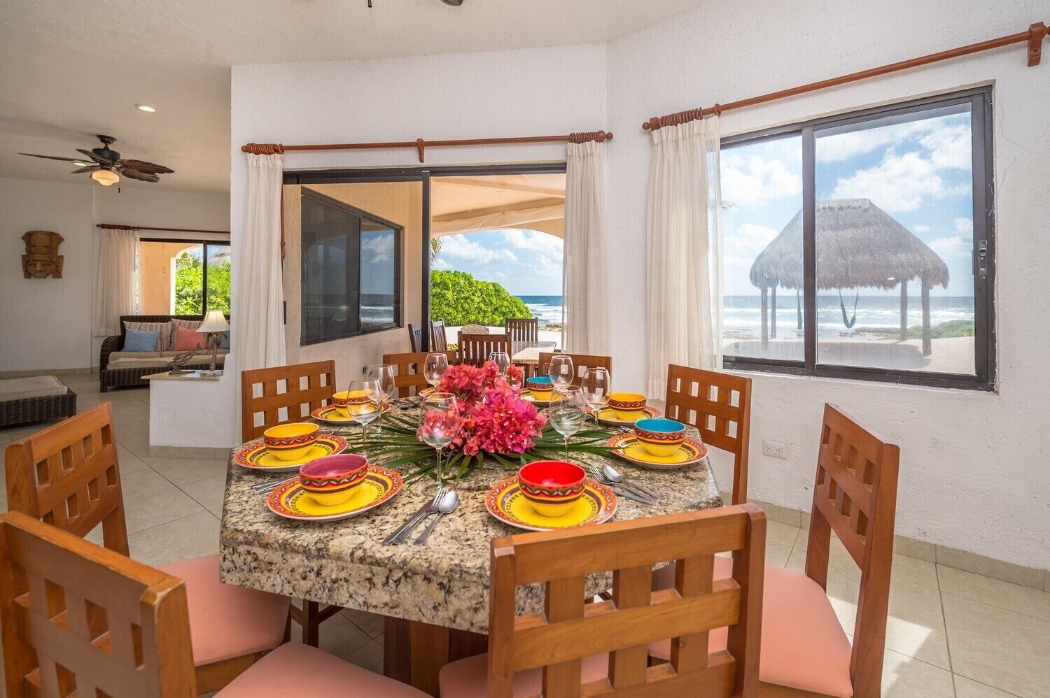 Un coin repas avec une table dressée pour six personnes, entourée de chaises en bois.