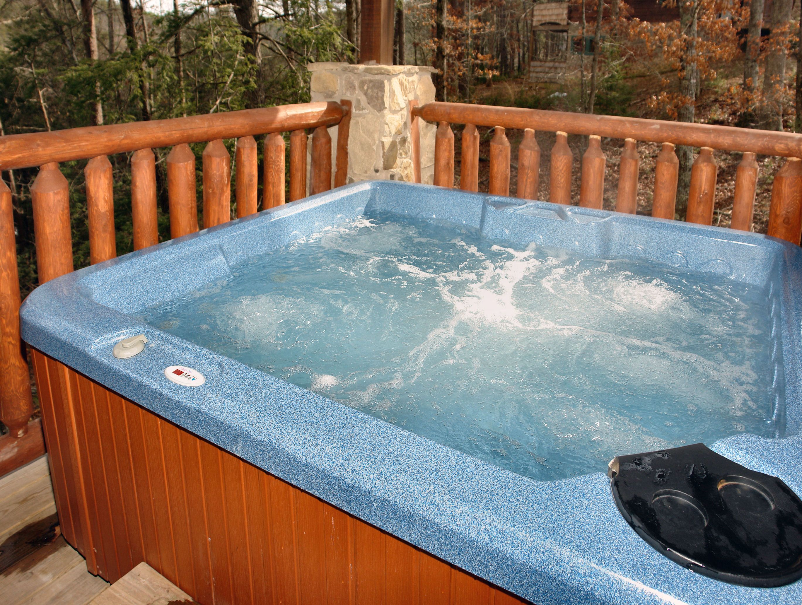Un bain à remous doté d’un panneau de commande et entouré d’une terrasse en bois.