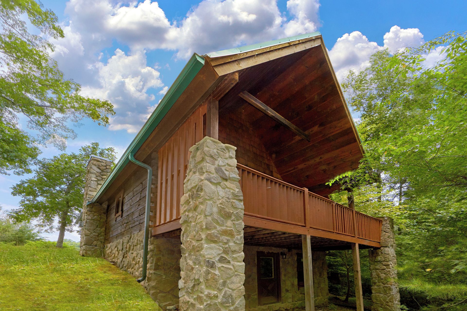 A rustic cabin with a stone foundation, wooden exterior, and a sloped roof.