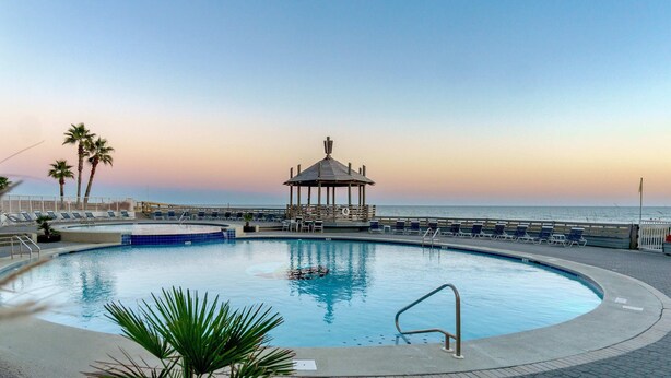 A pool with lounge chairs and a gazebo overlooking the ocean. - Summer House 703B - Great Beachfront Condo with Huge Balcony & Amazing Views! (Orange Beach)