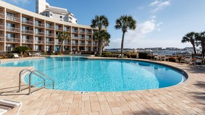 Un albergo con piscina, palme e vista sulla città.