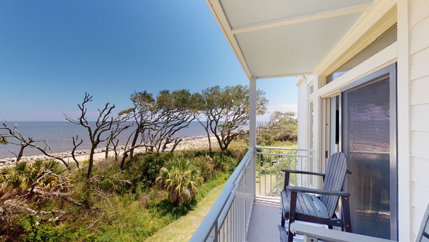 Ein Balkon mit Blick auf Strand und Meer.