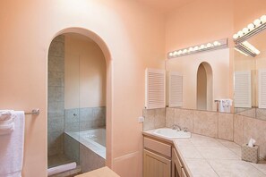 Ein Badezimmer mit Dusche, Waschbecken, Spiegel und Handtuchhalter.