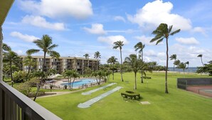 Un hôtel doté d’une piscine, de palmiers et offrant une vue sur l’océan.