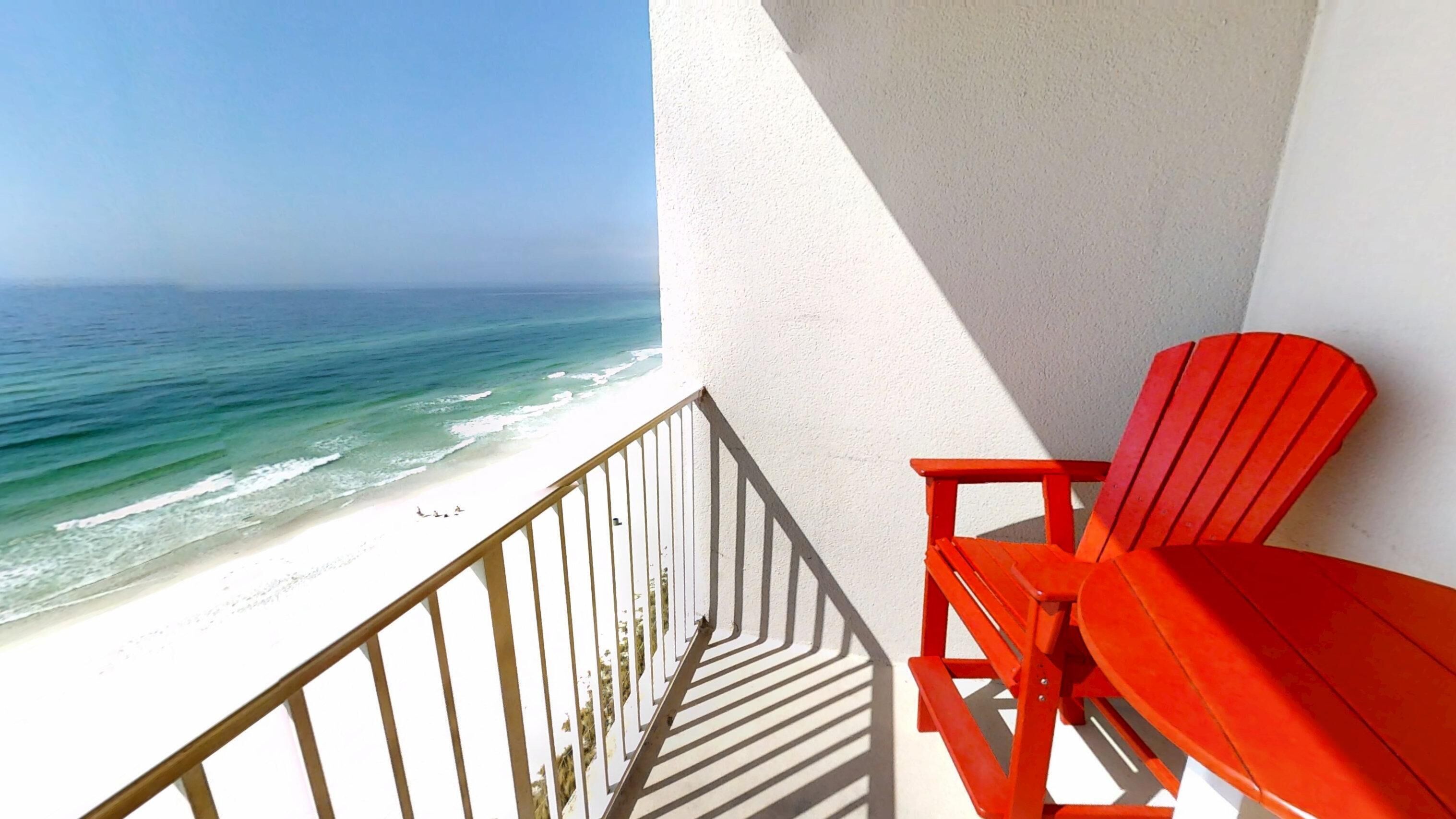A balcony with a view of the beach and ocean.