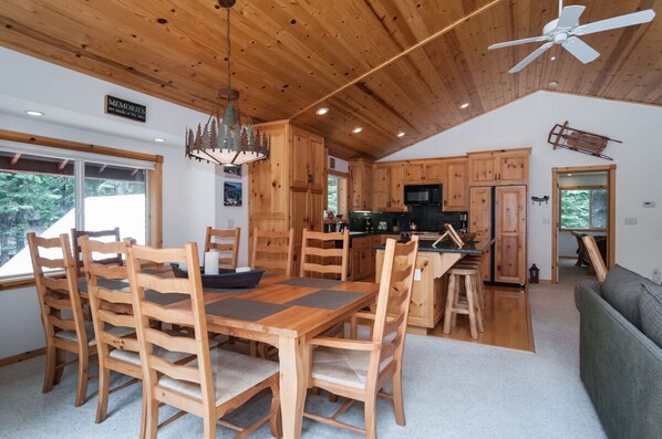 A spacious kitchen with wooden cabinets and a dining area with a large wooden table and chairs.