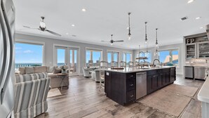 Un'ampia cucina con isola centrale, ampie finestre e ventilatori a soffitto.