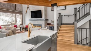 Una cocina moderna con una isla grande, lavavajillas integrado y chimenea.
