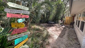A garden with a wooden signpost listing various locations such as 'Marsh Path', 'Driftwood Beach', and 'Huddle House'.