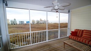 A covered porch with a white railing, a ceiling fan, and a view of beach houses. - 5BR Fort Morgan Gulf View Duplex (GULF SHORES)