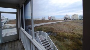 A view from a porch overlooking a beach with houses in the background. - 5BR Fort Morgan Gulf View Duplex (GULF SHORES)