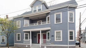 A two-story house with a front porch, a red door, and a small balcony. - Salem 3rd floor 3BR Apartment (Salem)