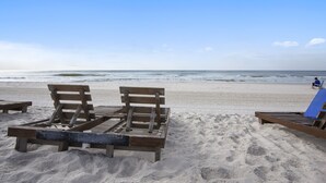 A beach with wooden lounge chairs and a clear view of the ocean. - Phoenix VII 213 | Beachfront | Pools | Fitness Center | My Beach Getaways (Orange Beach)