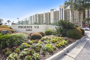 A landscaped area with a sign reading 'PHOENIX VII 26802' and a backdrop of high-rise buildings.