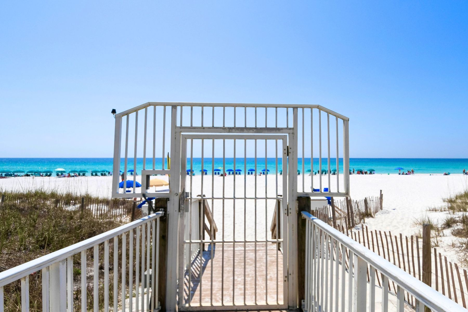 A beach entrance with a gated pathway leading to the shore.