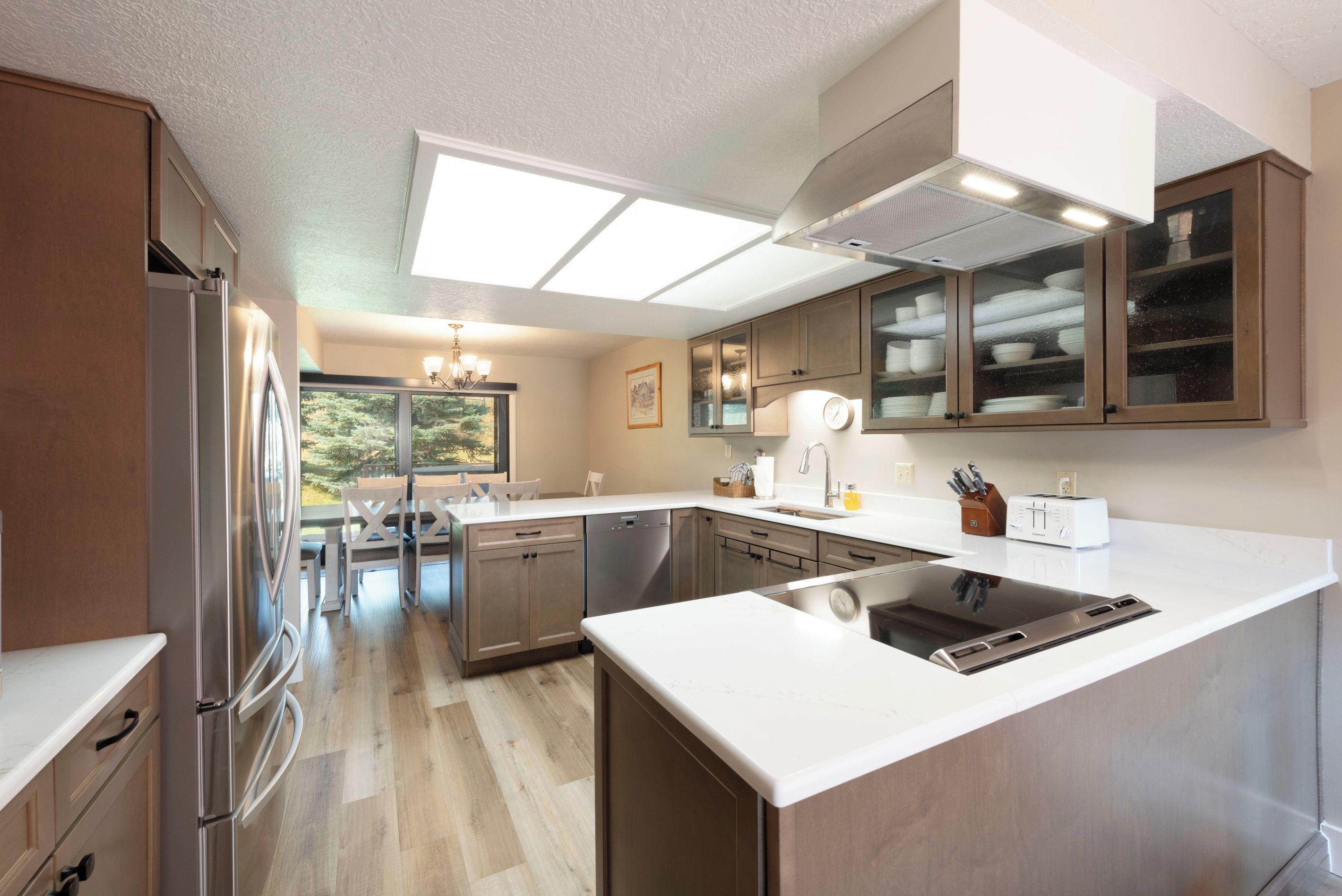 Una cocina moderna con lavavajillas integrado, refrigerador de acero inoxidable y una isla grande con pileta.