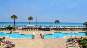 A pool area with lounge chairs and a beach in the background. - Gulf Front ~ 11th Floor ~ Beachfront Pool ~3BR Silver Beach East 1103 (Destin)