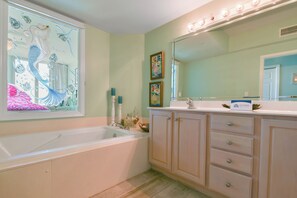 A bathroom with a bathtub, vanity with drawers, a large mirror, and decorative items. - Gulf-front Beachy Condo w/ Easy Beach Access & Large Balcony in Destin! 🏖🌊☀ (Destin)