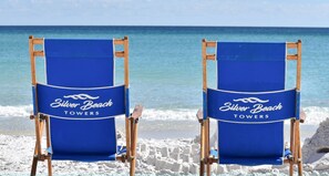 Two beach chairs with "Silver Beach Towers" branding on a sandy beach with the ocean in the background. - Gulf-front Beachy Condo w/ Easy Beach Access & Large Balcony in Destin! 🏖🌊☀ (Destin)