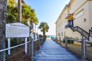 A wooden boardwalk leading to a beach with a sign detailing beach rules. - Stylish Beach Home w/Private Elevator & Beach Access (Destin)