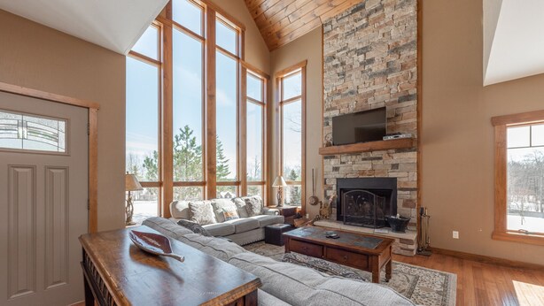 Amplia sala de estar con un sofá modular grande, una chimenea y ventanas amplias.