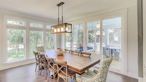 A dining room with a large wooden table, six chairs, and a hanging light fixture. - 3B Hickory Lane-CUSTOM built house!  200 Yards till your feet are in the sand (Hilton Head Island)
