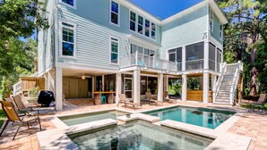 A two-story house with a pool area, outdoor seating, and a covered patio. - 3B Hickory Lane-CUSTOM built house!  200 Yards till your feet are in the sand (Hilton Head Island)