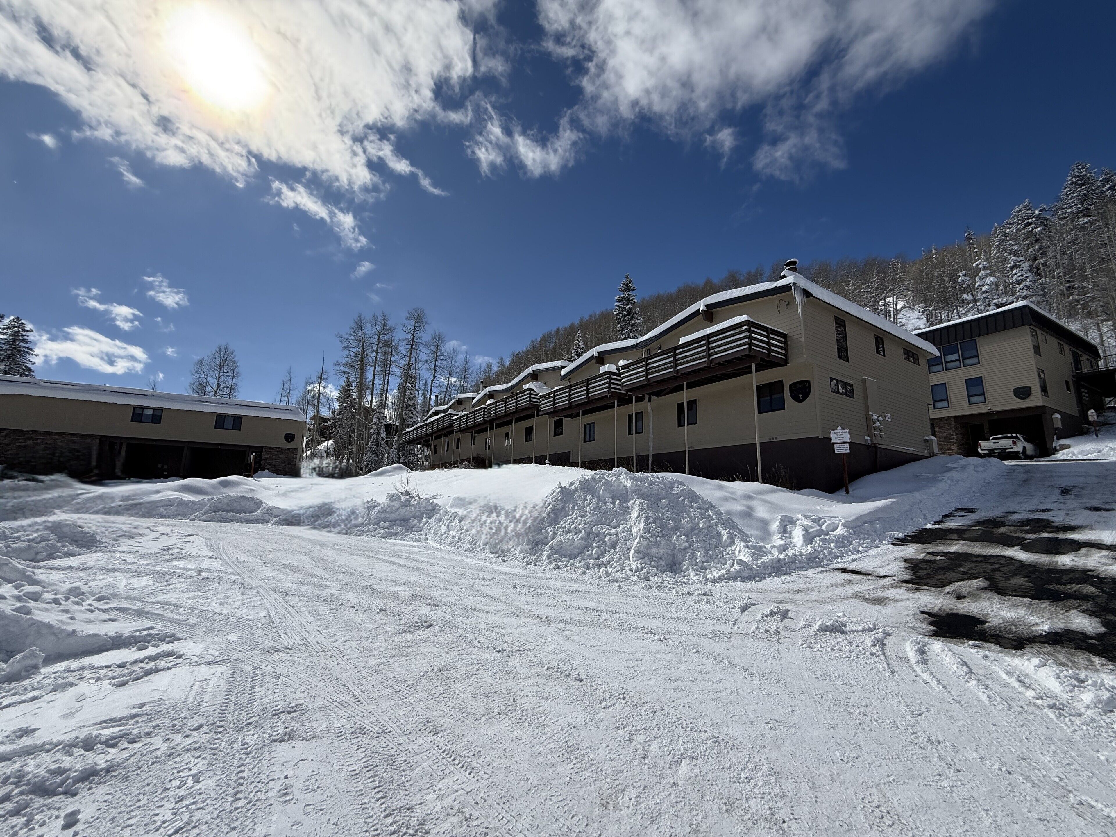 A snow-covered building with multiple balconies and a clear sky.