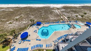 A resort with a large pool area, multiple sun loungers, and a view of the beach. - Phoenix VI 811 | Beachfront | Pickleball | Pools | My Beach Getaways (Orange Beach)