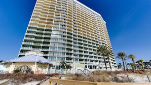A high-rise hotel with multiple balconies, a beachside location, and a wooden boardwalk. - Boardwalk Beach Resort Family Getaway with Splash Zone and Gulf Views (Panama City Beach)