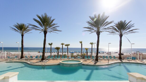 A pool with a view of the beach and palm trees. - Boardwalk Beach Resort Family Getaway with Splash Zone and Gulf Views (Panama City Beach)