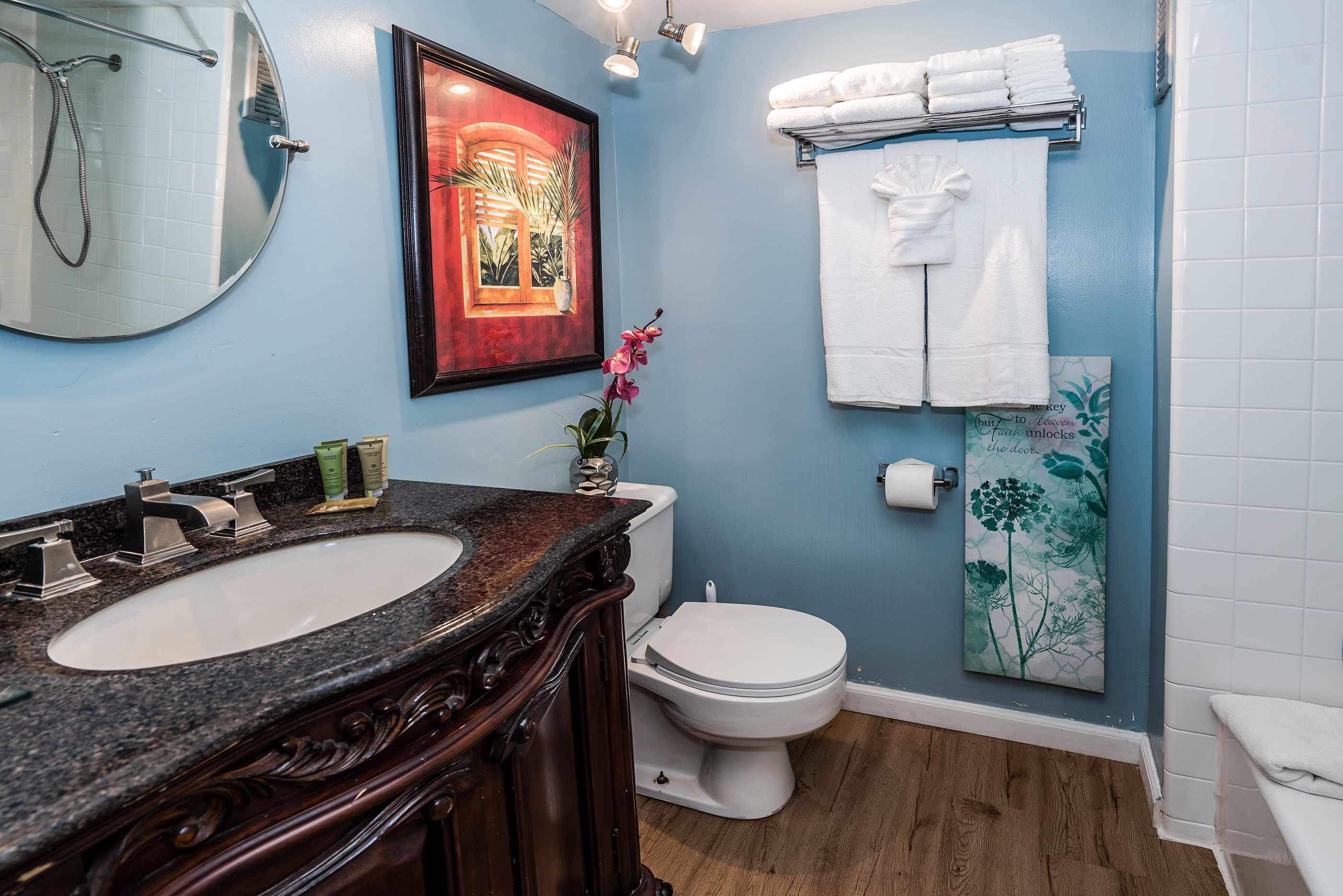 A bathroom with a sink, toilet, and towel rack.