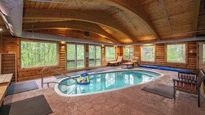 A wooden cabin with a swimming pool, large windows, and a bench.