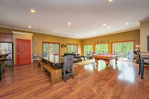 A spacious living room with a pool table, comfortable seating, and large windows. - Cozy Rooms, Indoor Pool, Lake Perks & Hot Tub (McHenry)