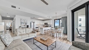 Un salon moderne comprenant un canapé, une table basse et un coin repas avec des chaises et une table.