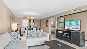 A living room with a sofa, coffee table, TV, and entertainment center.