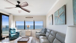 Un saló amb vista a l'oceà, un ventilador de sostre i dues butaques.