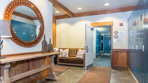 A reception area with a wooden bench, a large mirror, and a bench with pillows. - Zephyr Mountain Lodge 2315 | Ski In Ski Out | Walk To Base Area (Winter Park)