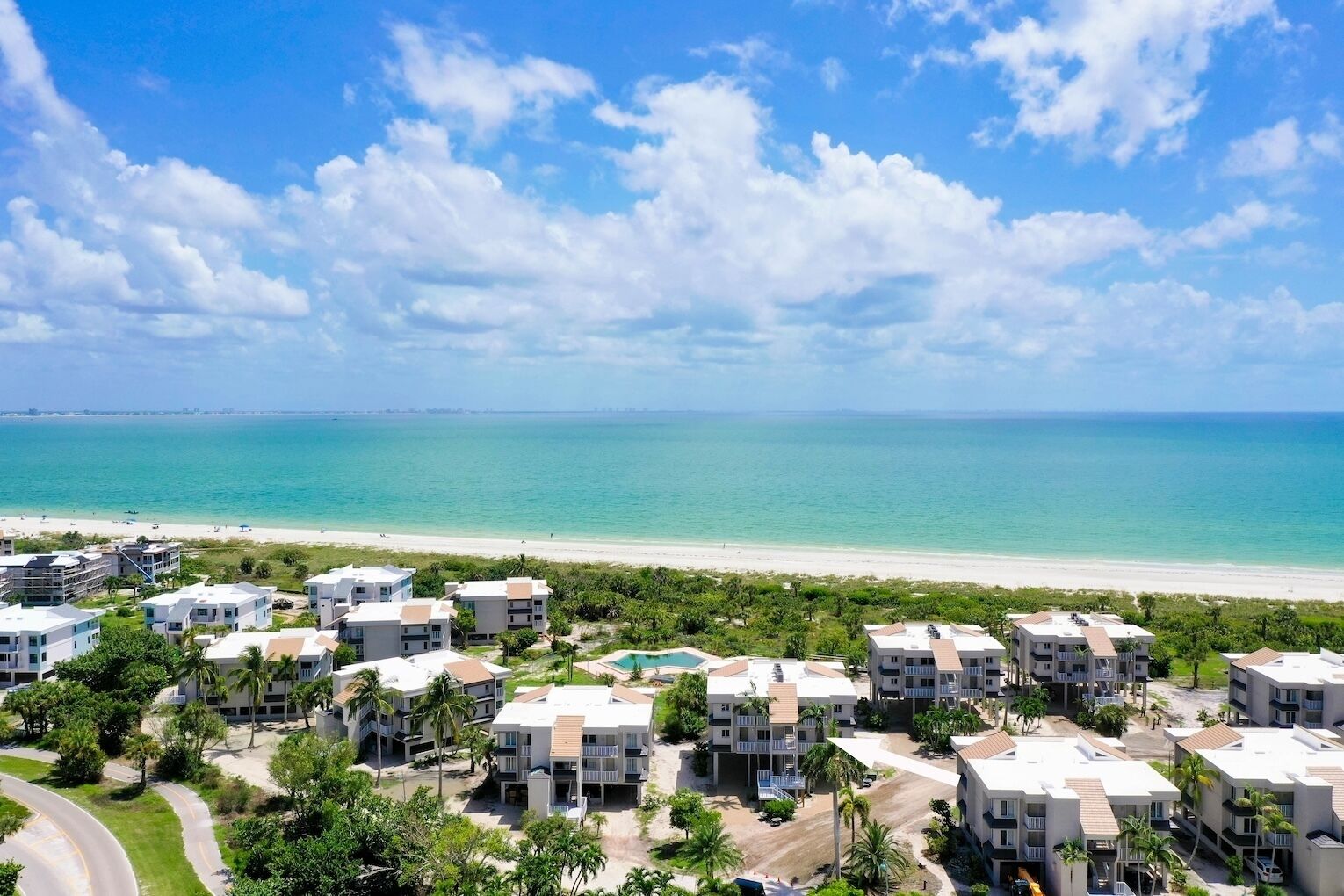 Un complexe hôtelier doté de villas en bord de mer, d’une piscine et offrant une vue sur l’océan.
