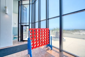 Enjoy a view of the beach and surrounding vegetation from the comfort of this room, featuring a large window and a blue decorative barrier.