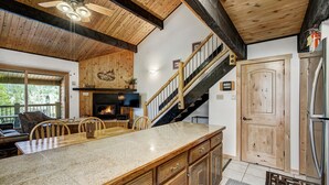 Une cuisine dotée d’un îlot central en bois, d’une cuisinière intégrée et d’un escalier menant à un niveau supérieur.