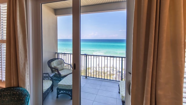 A balcony with a view of the ocean and beach.