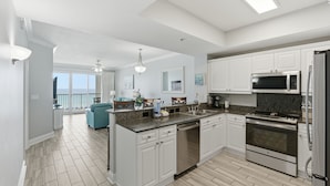 Una cocina moderna con armarios blancos, electrodomésticos de acero inoxidable y una isla grande.