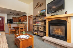 Cozy living room with a fireplace, television, and dining area.